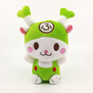 A photo of the Fukkachan Maracas Plushie from the front. This stuffed animal toy is cute! Fukkachan's soft fur is white, and their suspenders and little hat are green, along with the tips of their green onion horns!with pink blushes beside their brown eyes and extra-cute mouth, Fukkachan has their arms raised as if they are happy to see you! On the front and center of their hat is the Japanese hiragana character 'fu', because Fukkachan is the mascot of Fukaya City.